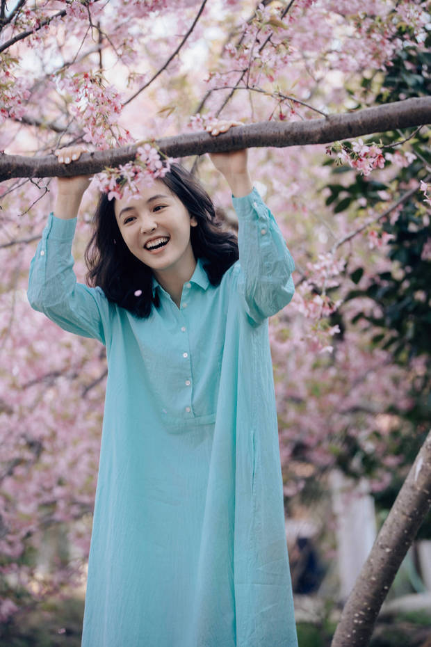 吴倩在樱花树下笑得甜美可爱。