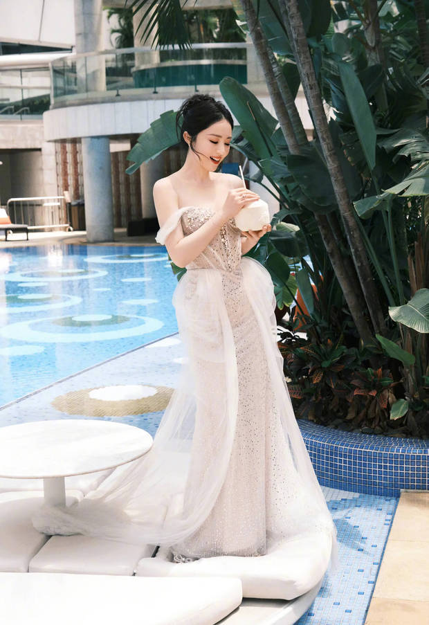 搜狐娱乐讯 近日，董璇在社交平台上晒出一组写真美照，并配文称：“提前在广州感受了夏日赛道。”照片中，她身着一袭优雅礼裙在游泳池旁喝椰子水，面露明媚笑容，十分惬意。