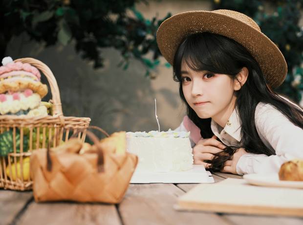 田曦薇头戴草帽，表情娇憨。